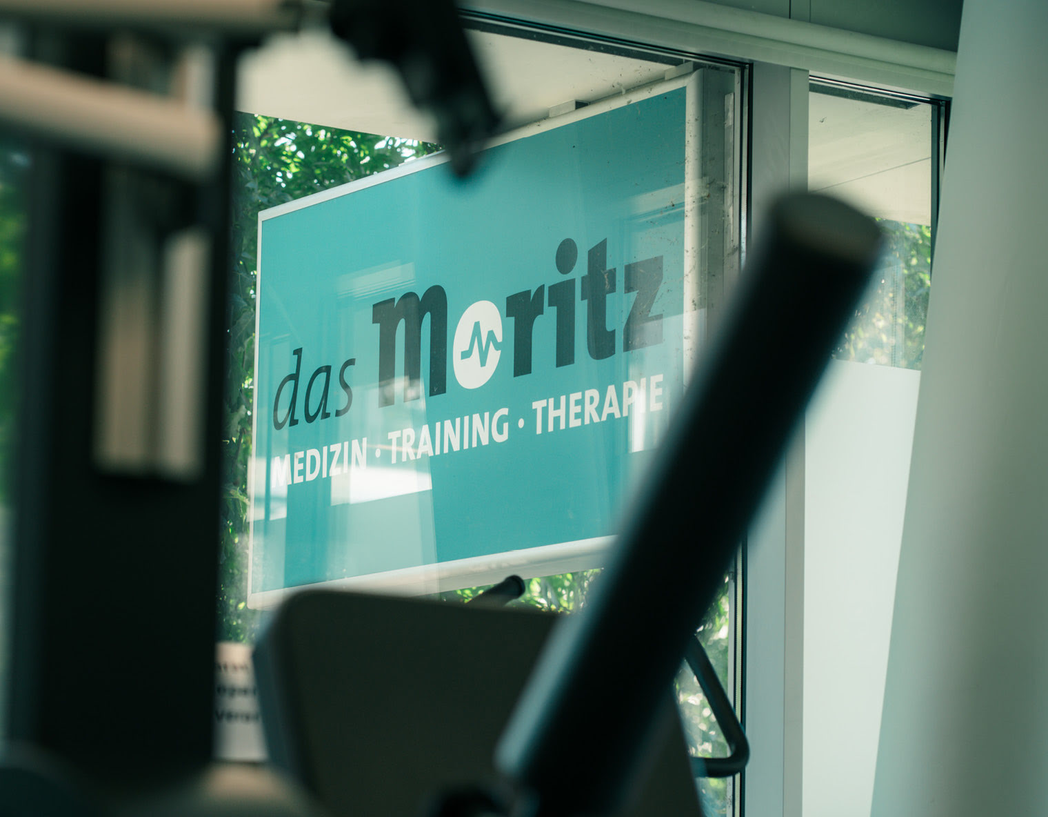 Durch ein Fenster blickt man auf das Schild des das Moritz