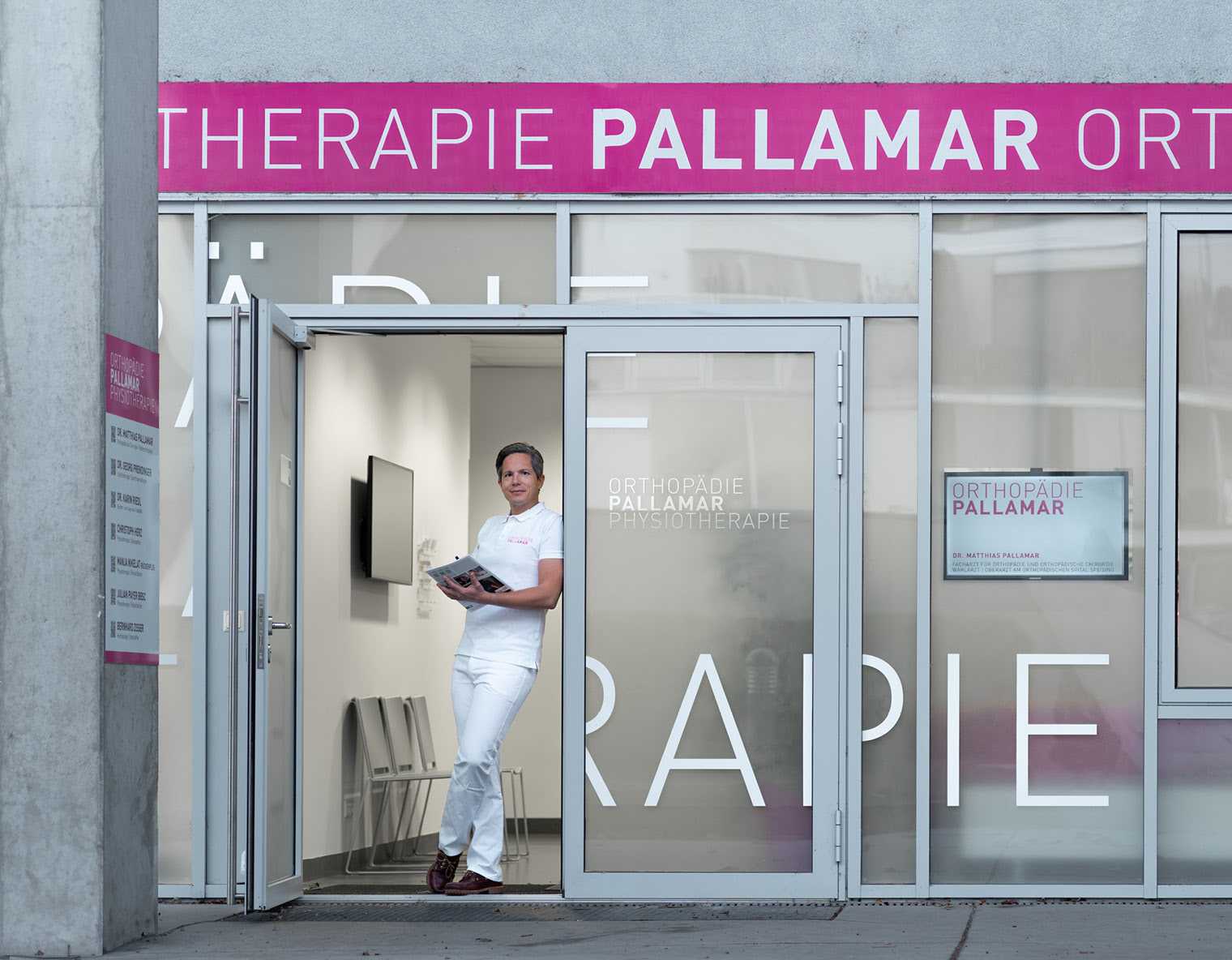 Dr. Med. Matthias Pallamar steht vor dem Eingangsportal der Orthop&auml;die Pallamar